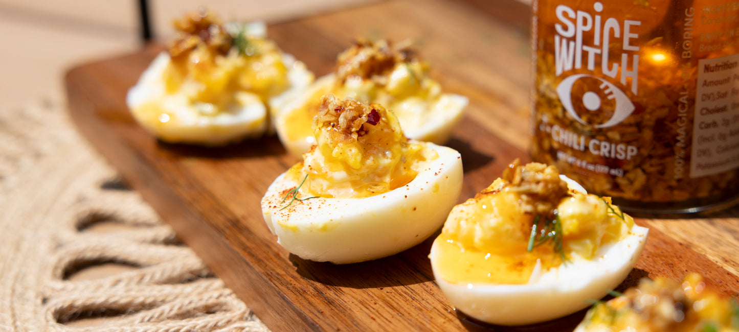 Plate of deviled eggs topped with Spice Witch Chili Crisp, adding a burst of flavor and spice to the classic appetizer.