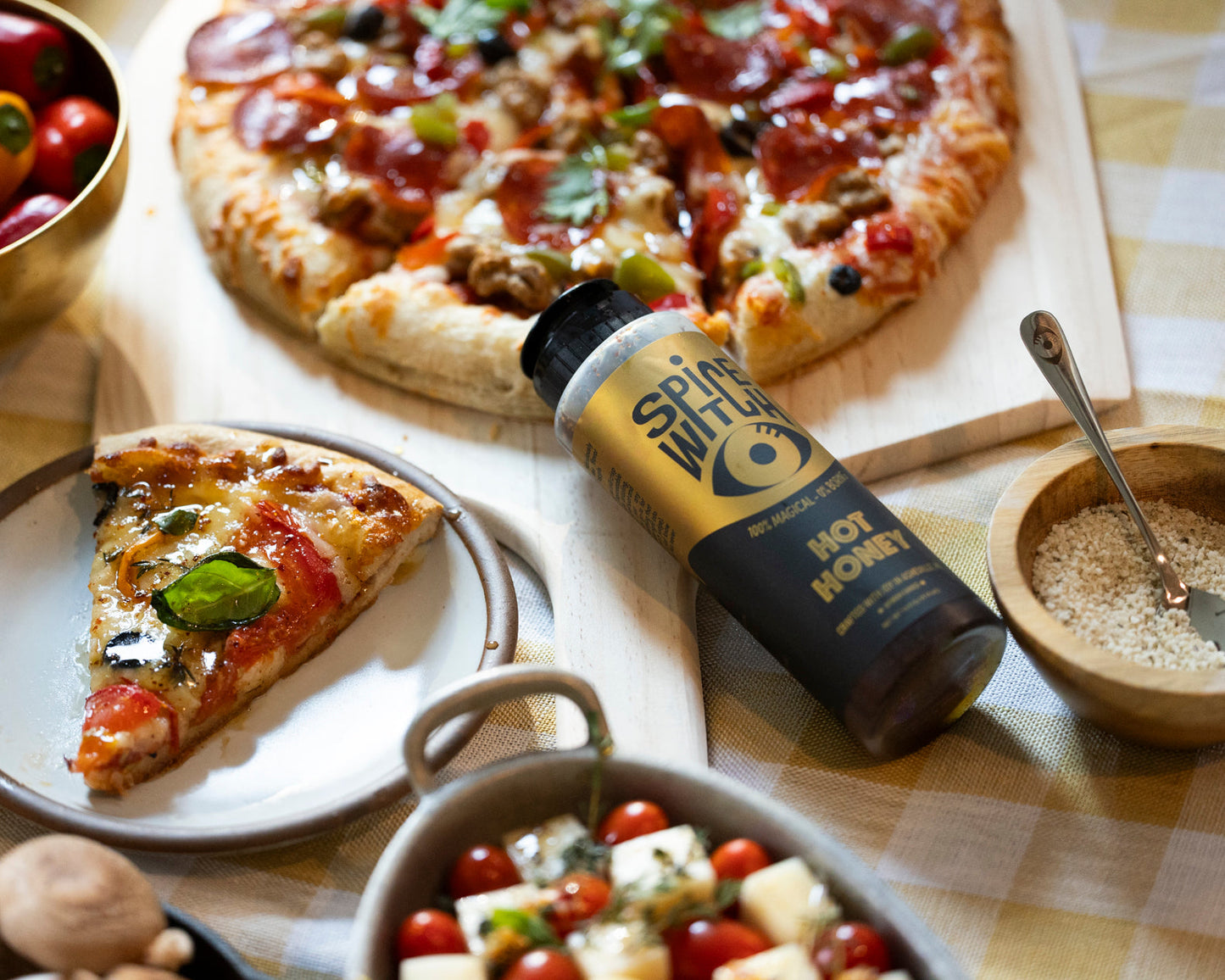 Hot honey drizzled on pizza — Spice Witch Hot Honey squeeze bottle over a slice