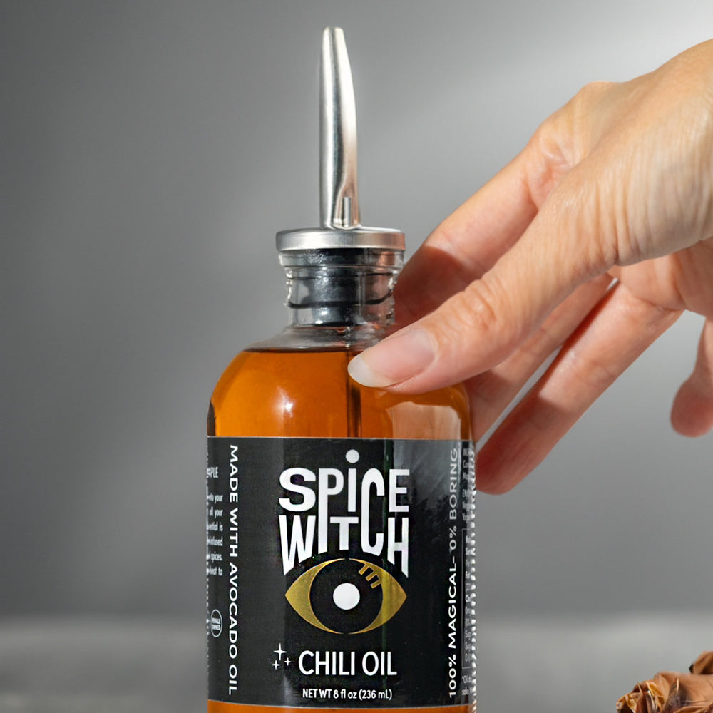 Discover the bold and flavorful Spice Witch Chili Oil, crafted with premium avocado oil, garlic, ginger, and aromatic spices. Featuring an elegant gold spout, this versatile chili oil adds a spicy kick to any dish. Perfect for cooking, drizzling, and dipping, it enhances stir-fries, soups, marinades, pizzas, pastas, salads, and vegetables. Elevate your culinary creations with Spice Witch Chili Oil, your essential for gourmet flavor.